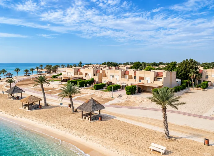 شاليهات منتجع شاطئ النخيل ومظلّاته على الشاطئ